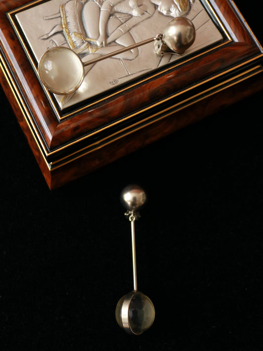 1970s vintage long drop clip-on earrings with translucent spherical resin pendants and silver-tone metal details on black velvet.