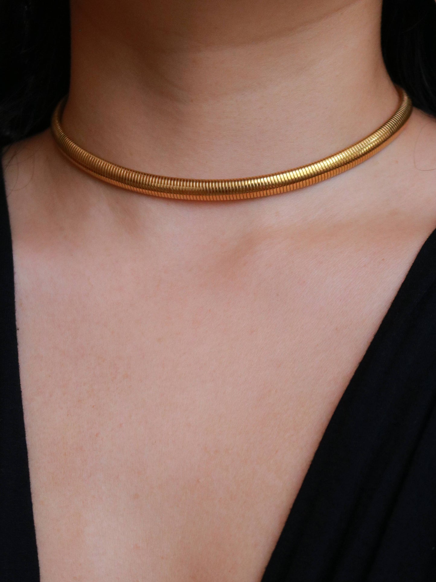 Vintage gold tone snake chain choker necklace worn on model, showcasing its elegant minimalist silhouette.