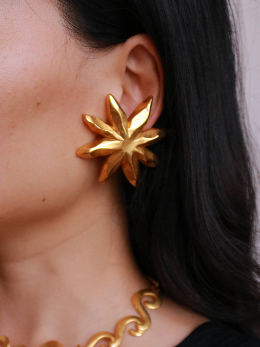 Vintage Christian Lacroix starburst clip-on earrings worn on model, showcasing their bold sculptural silhouette and iconic French design.