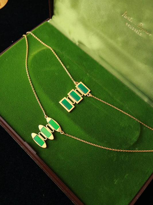Vintage vermeil geometric pendant necklace set with green jade on a green velvet jewelry box.