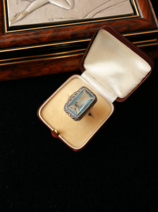 Vintage 925 sterling silver blue topaz and marcasite statement ring displayed in an antique jewellery box.