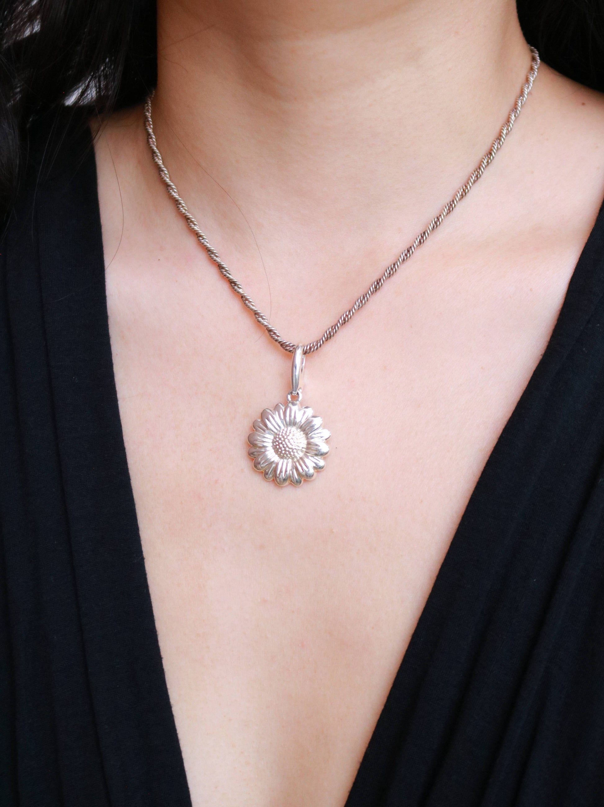 Vintage daisy pendant necklace worn to showcase its delicate floral design and 41 cm silver chain.