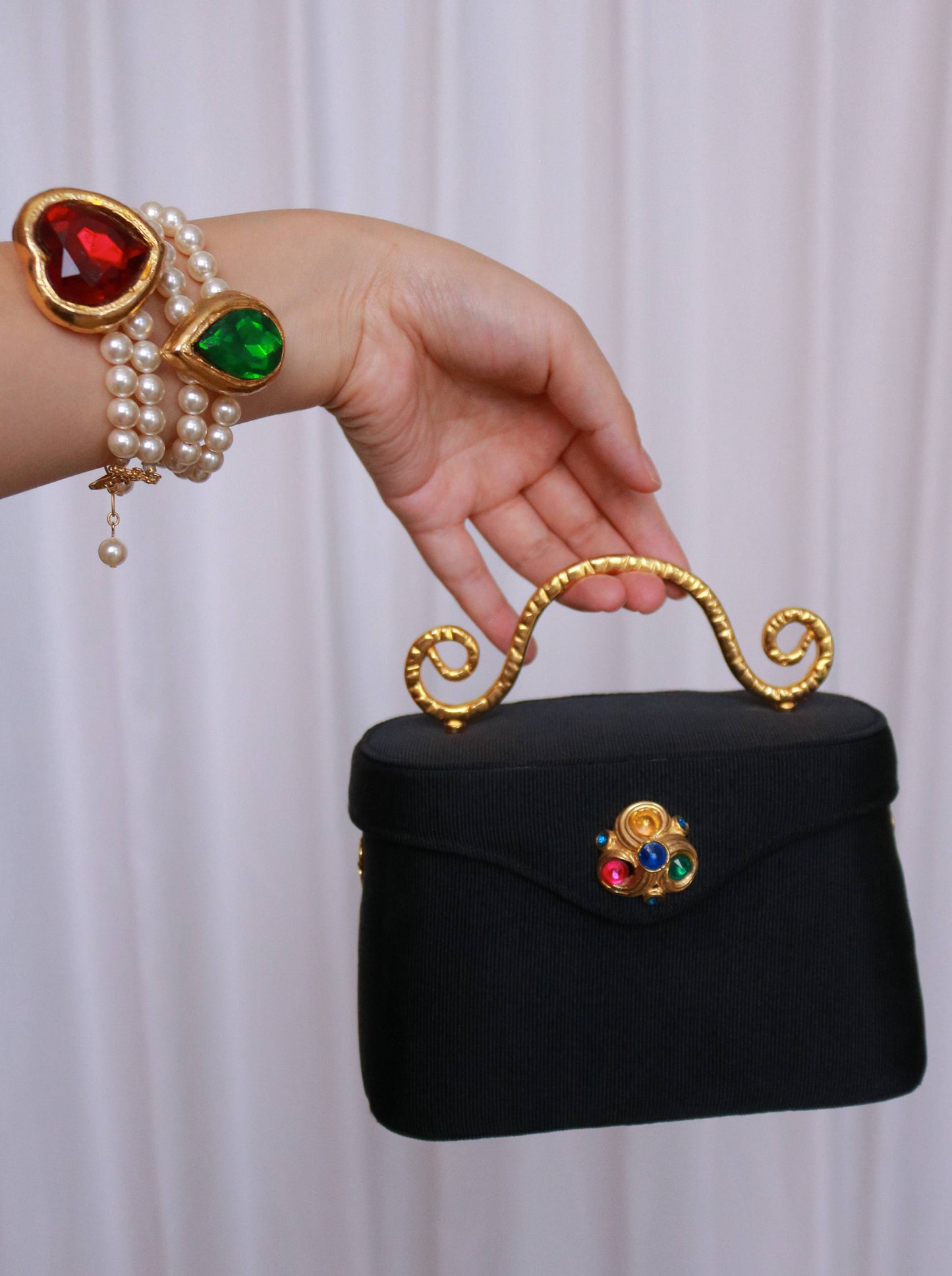 Vintage Edouard Rambaud black handbag with sculptural gold-tone handle and colourful cabochon embellishment.