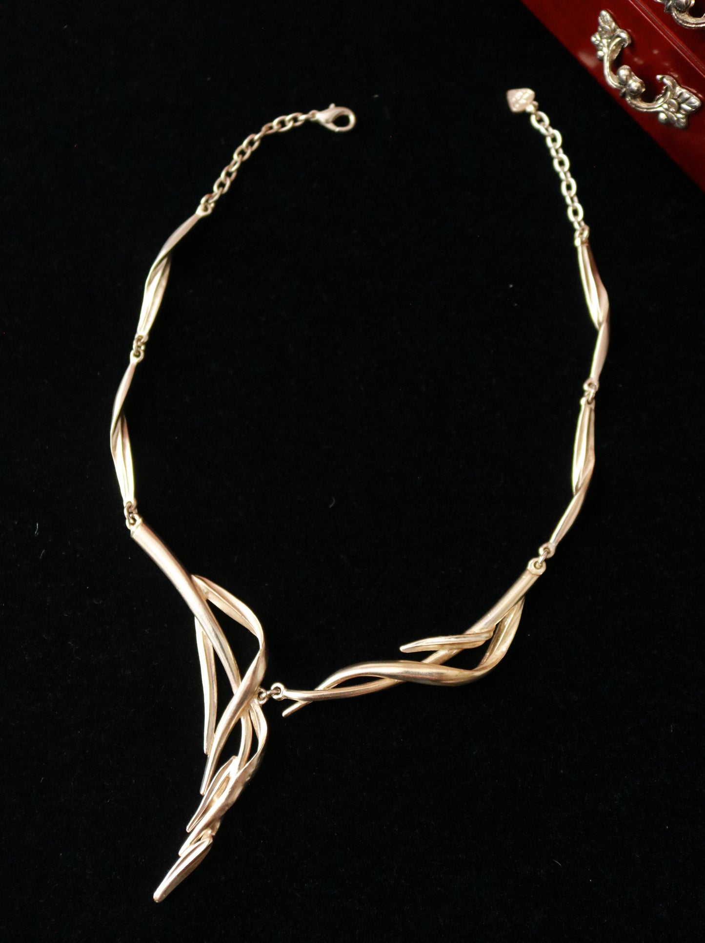 vintage Signed Dolce Vita asymmetric sculptural statement necklace with flowing intertwined metal forms displayed on black velvet.