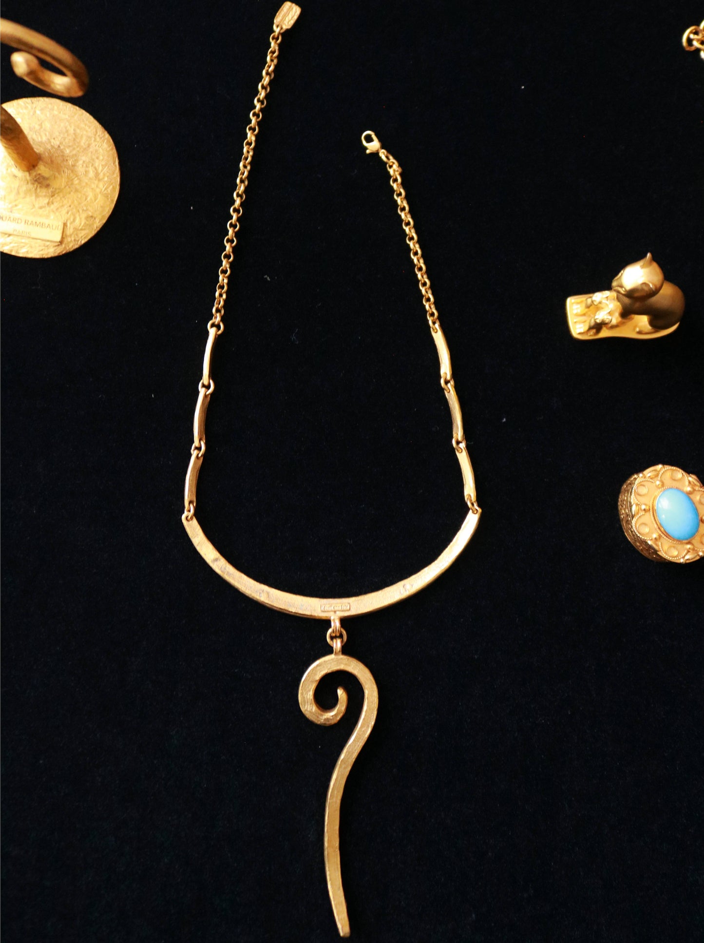 Close-up of signed Il Était Une Fois vintage gold-tone collar necklace featuring a hammered curved design and elongated spiral drop.