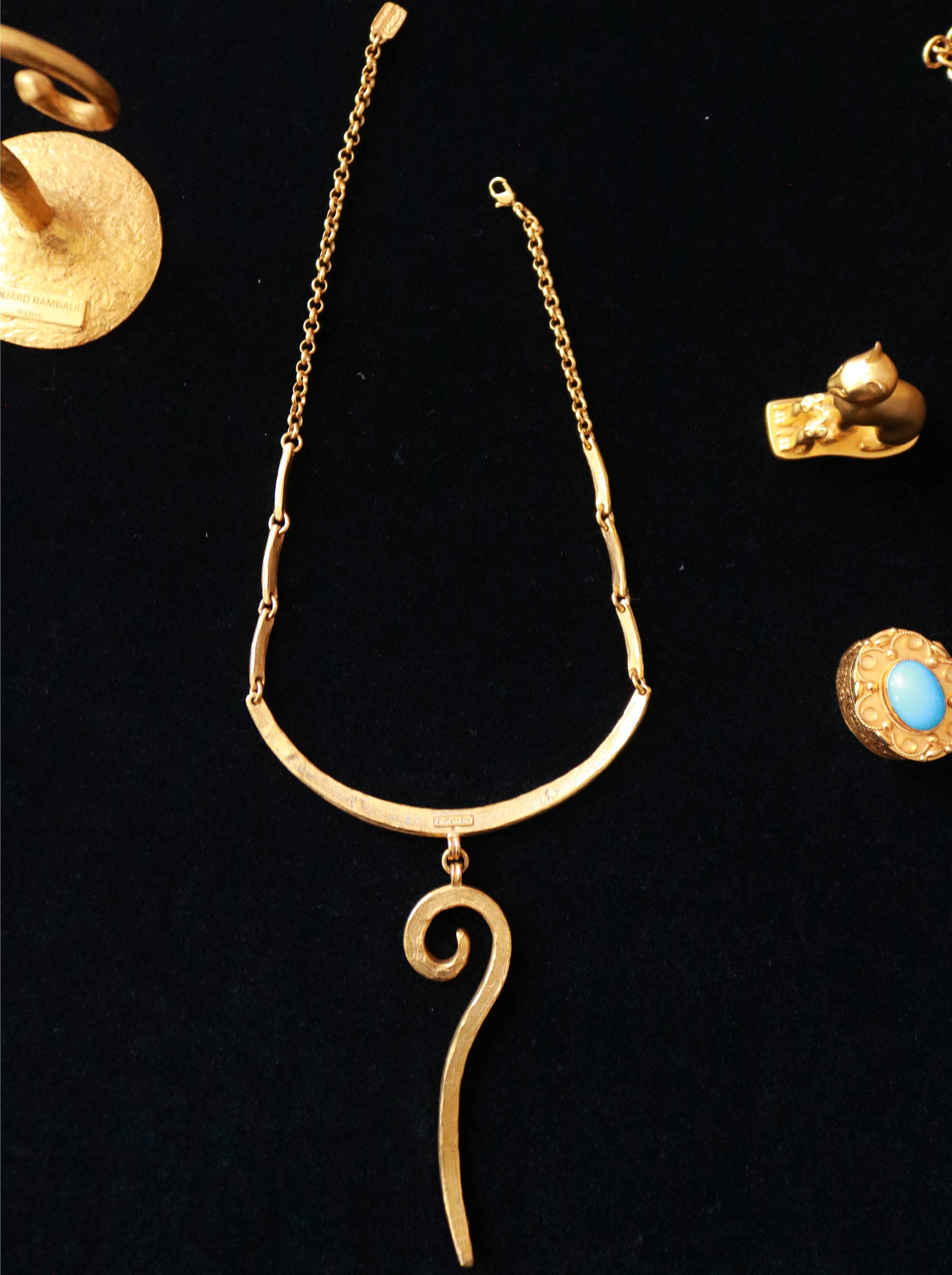 Close-up of signed Il Était Une Fois vintage gold-tone collar necklace featuring a hammered curved design and elongated spiral drop.