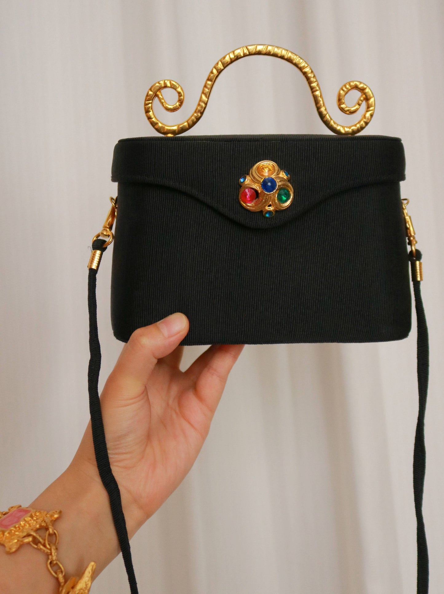 Edouard Rambaud vintage black handbag shown with its shoulder strap for scale and styling.