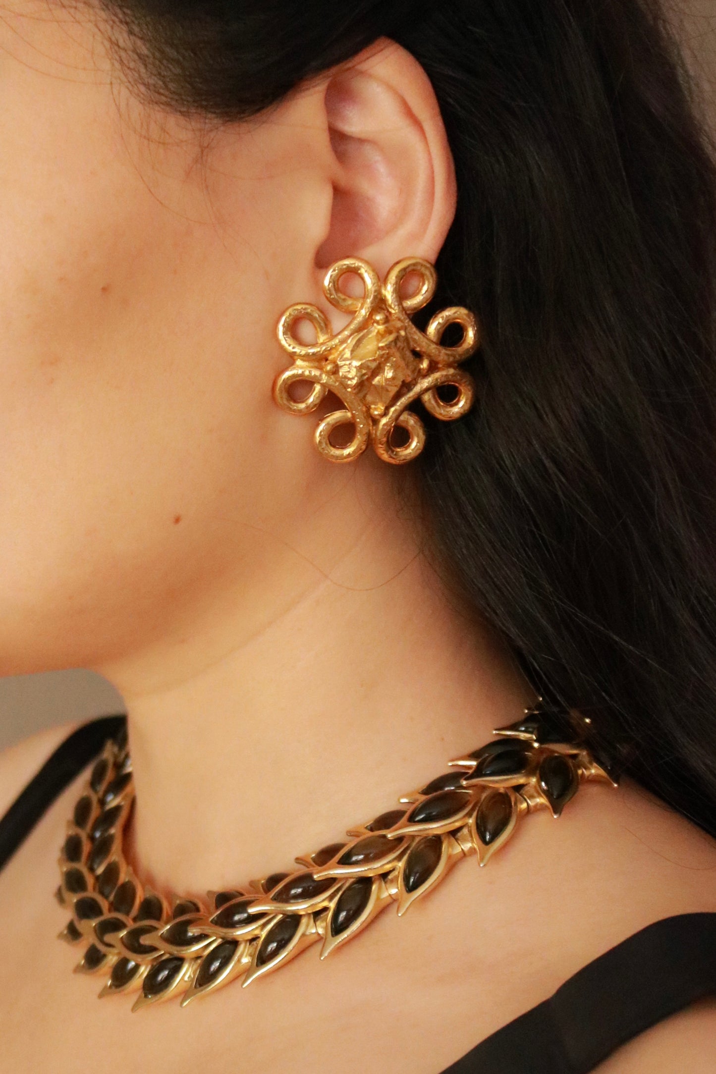Authentic Yves Saint Laurent lava gold clip-on earrings worn on model, 1990s vintage French designer jewelry.