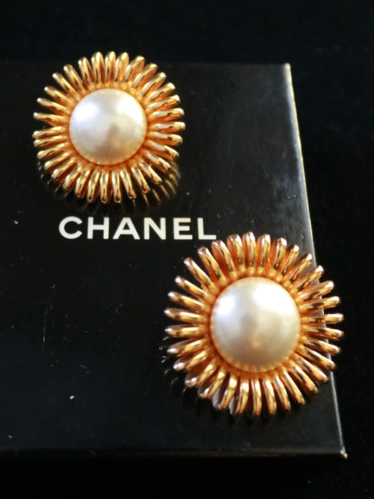 Authentic vintage Chanel daisy clip-on earrings by Karl Lagerfeld, 1984, featuring faux pearl centers and gold-plated sunburst petals.