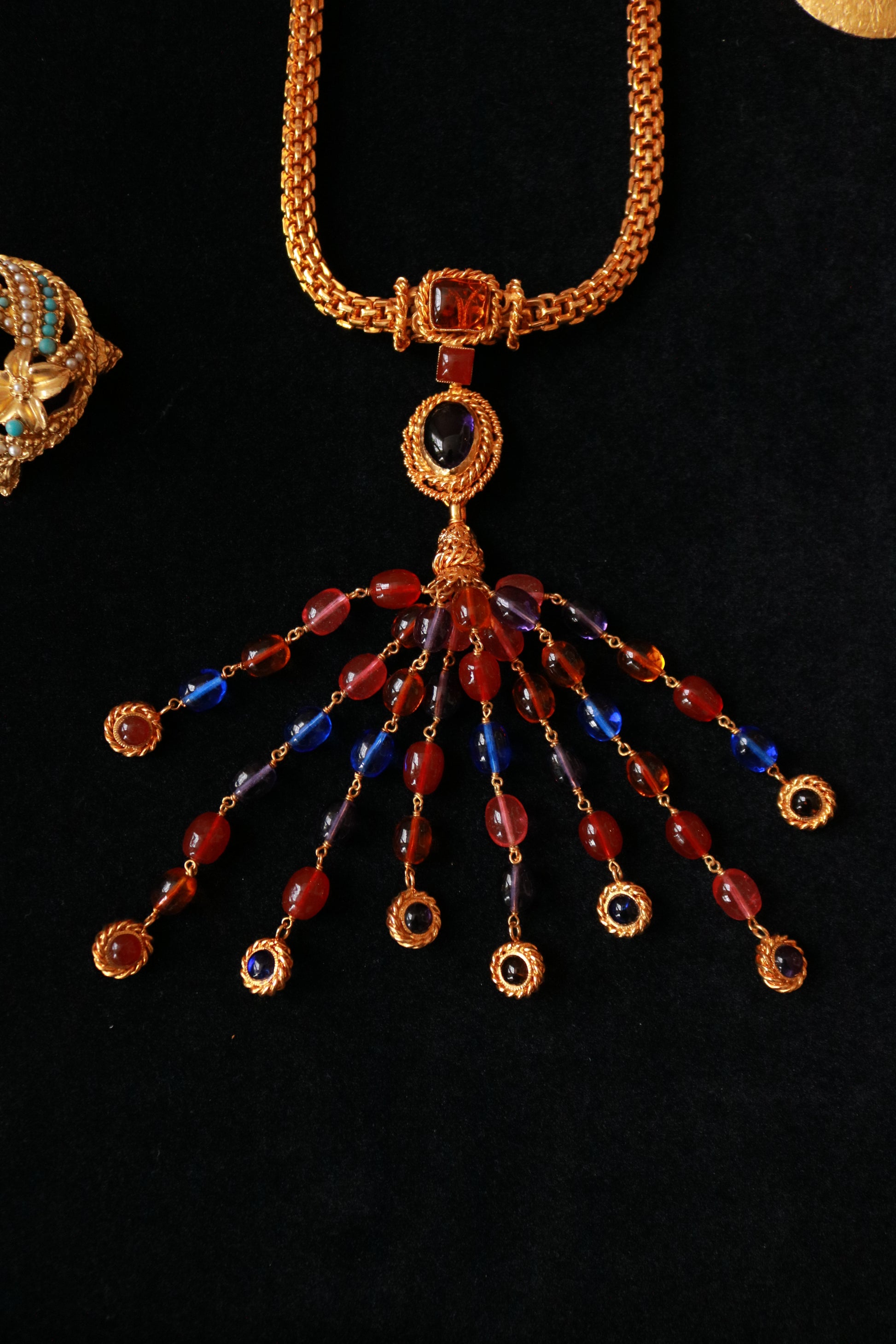 Close-up of authentic Chanel Haute Couture Gripoix necklace with red and blue handcrafted glass cabochons and ornate gold-tone detailing.
